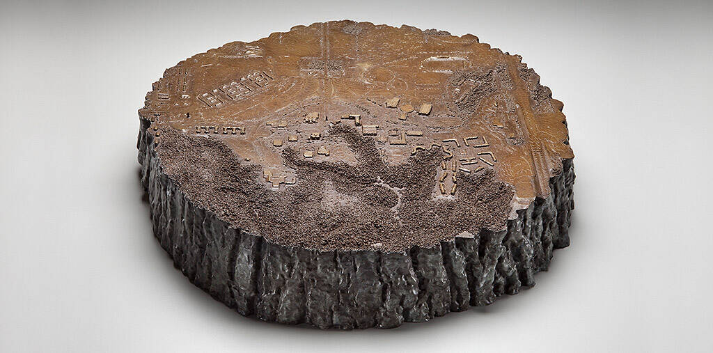 Cast bronze cross-section of tree trunk with a map of a city.